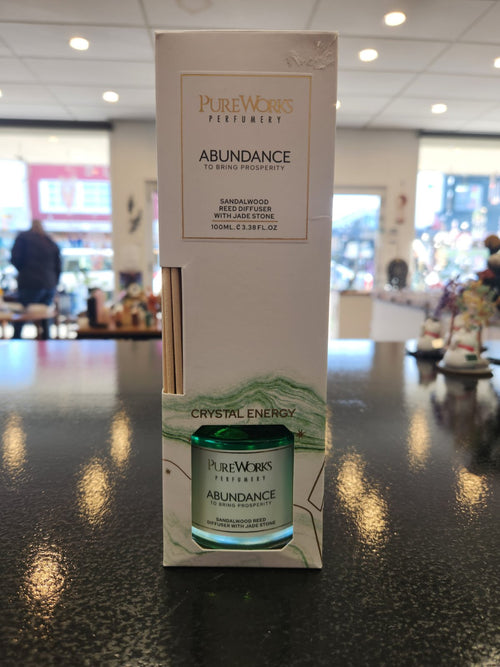 PureWorks Abundance Sandalwood Reed Diffuser with Jade Stone in white packaging displayed on counter