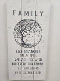Wooden wall art with tree illustration and family quote on white painted wood planks