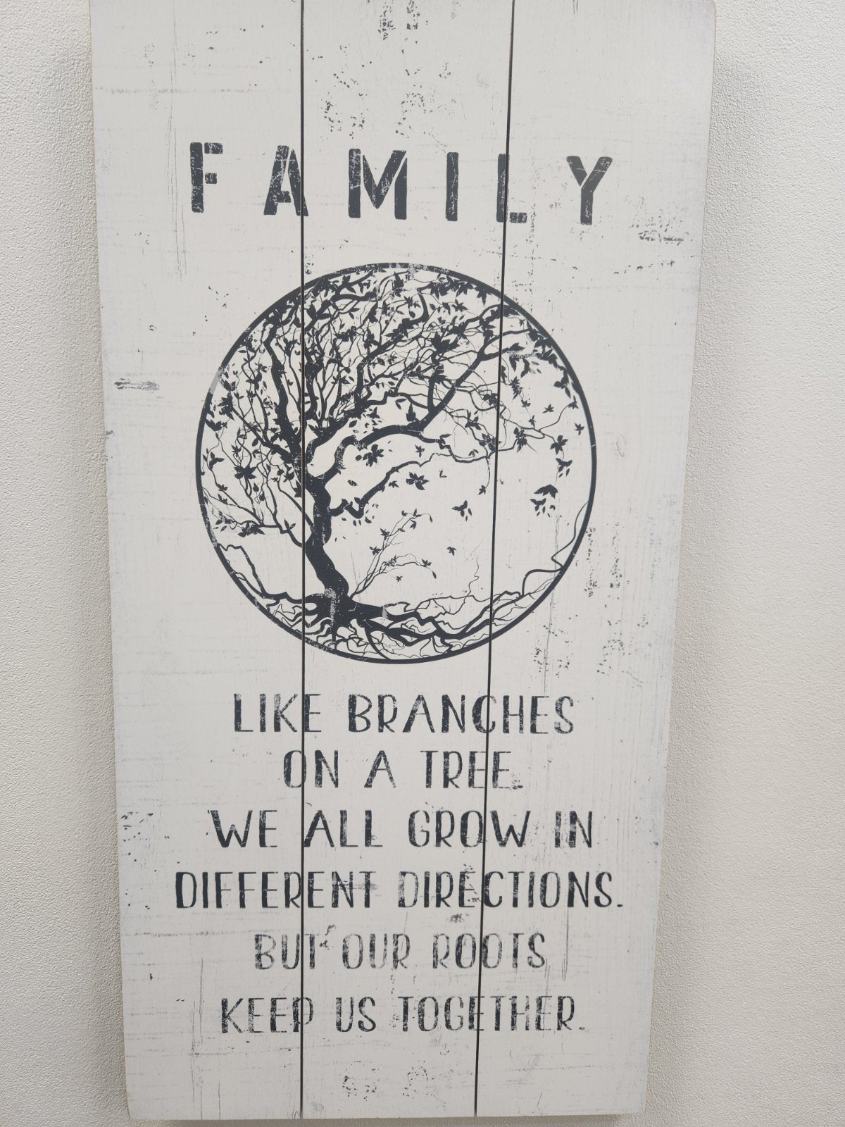 Wooden wall art with tree illustration and family quote on white painted wood planks