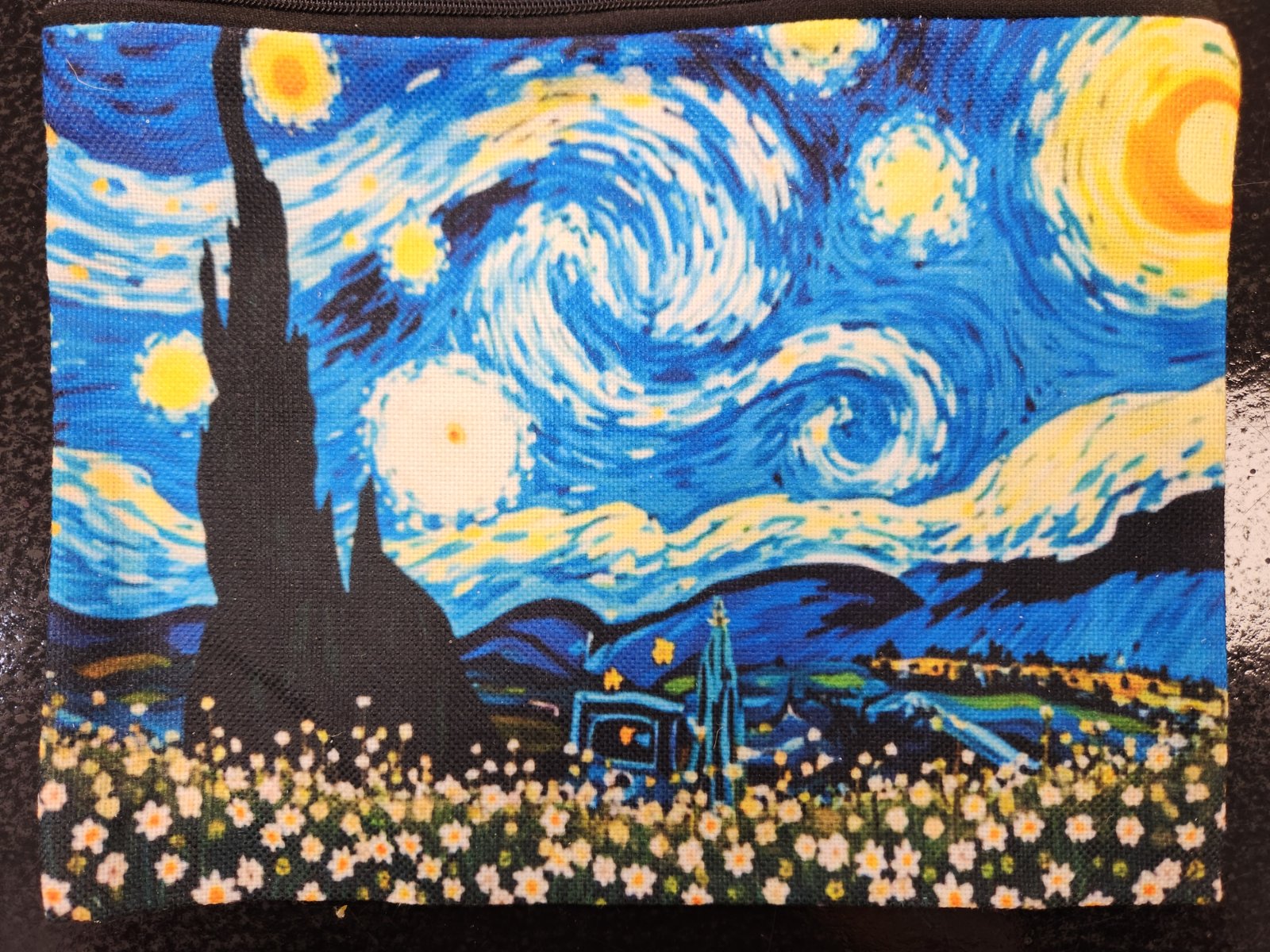 Large makeup bag featuring Van Gogh's Starry Night design with blue swirling sky, yellow stars and moon, black cypress tree, and white flower field at base