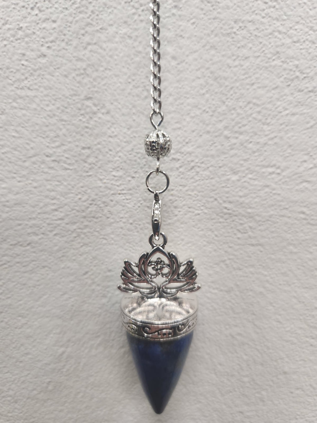 Lapis Lazuli Lotus Pendulum with silver filigree cap and chain against white wall