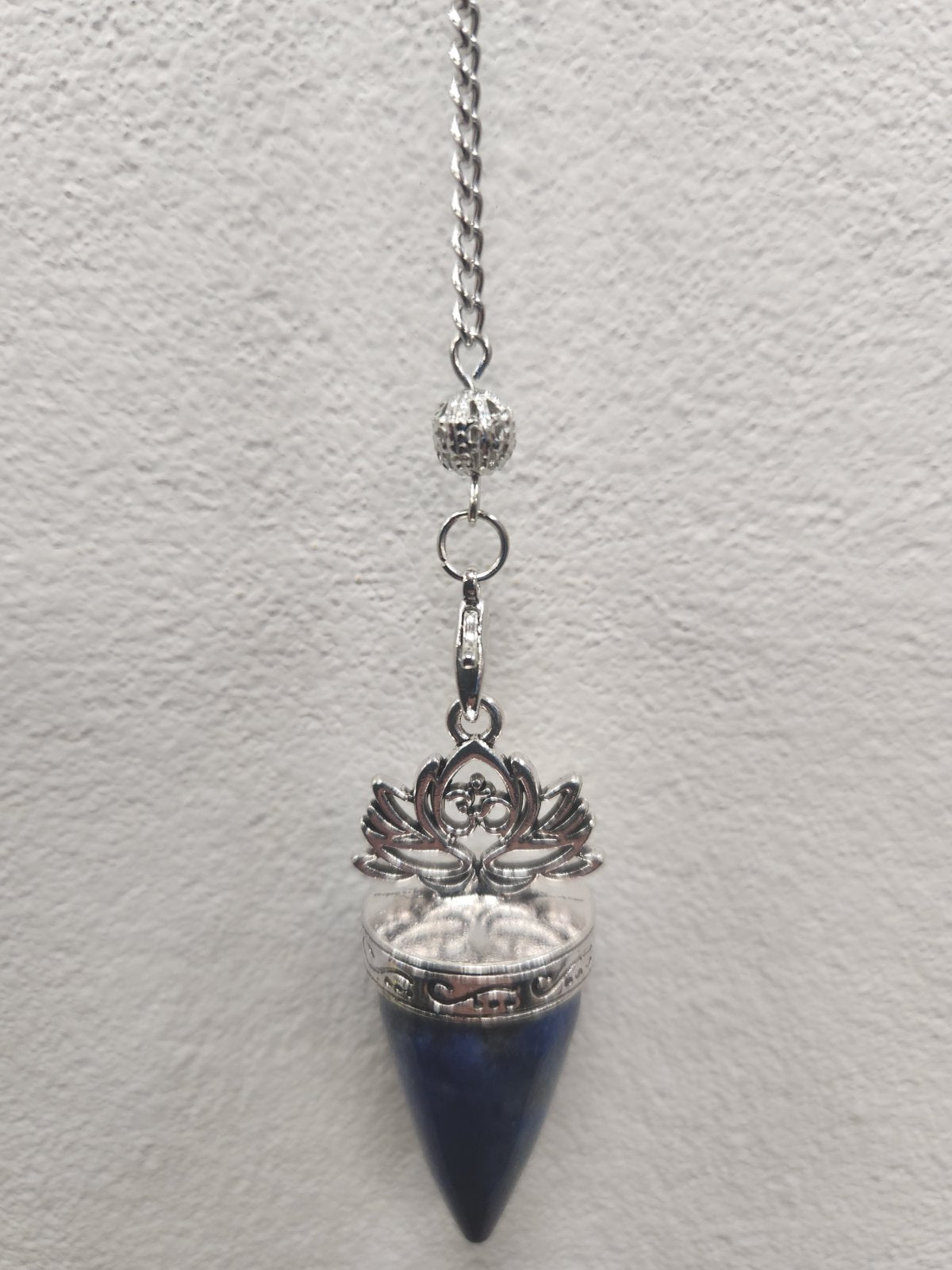 Lapis Lazuli Lotus Pendulum with silver filigree cap and chain against white wall