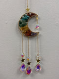 Gold crescent moon suncatcher filled with colorful chakra chips, with matching crystal pendants and stars hanging below