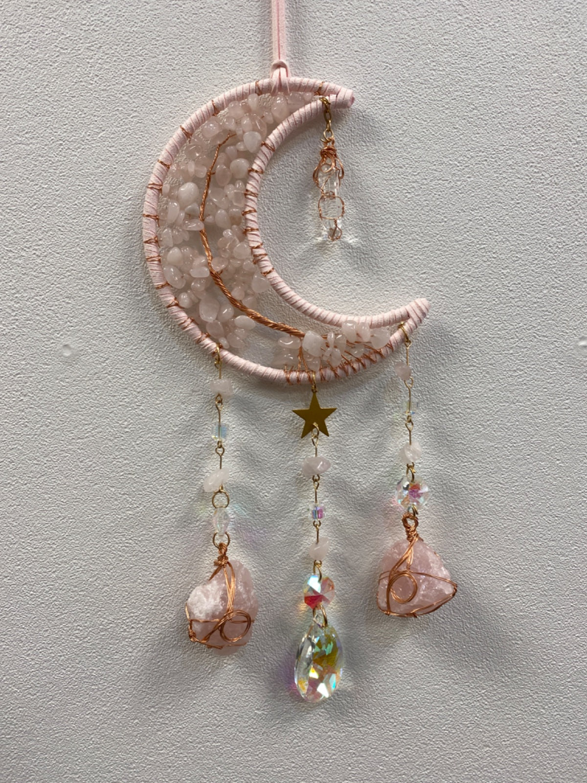 Rose quartz chip moon-shaped hanger with dangling raw rose quartz chunks and iridescent crystal accents