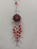 Red lotus metal suncatcher with dangling red and iridescent crystals on metal chain