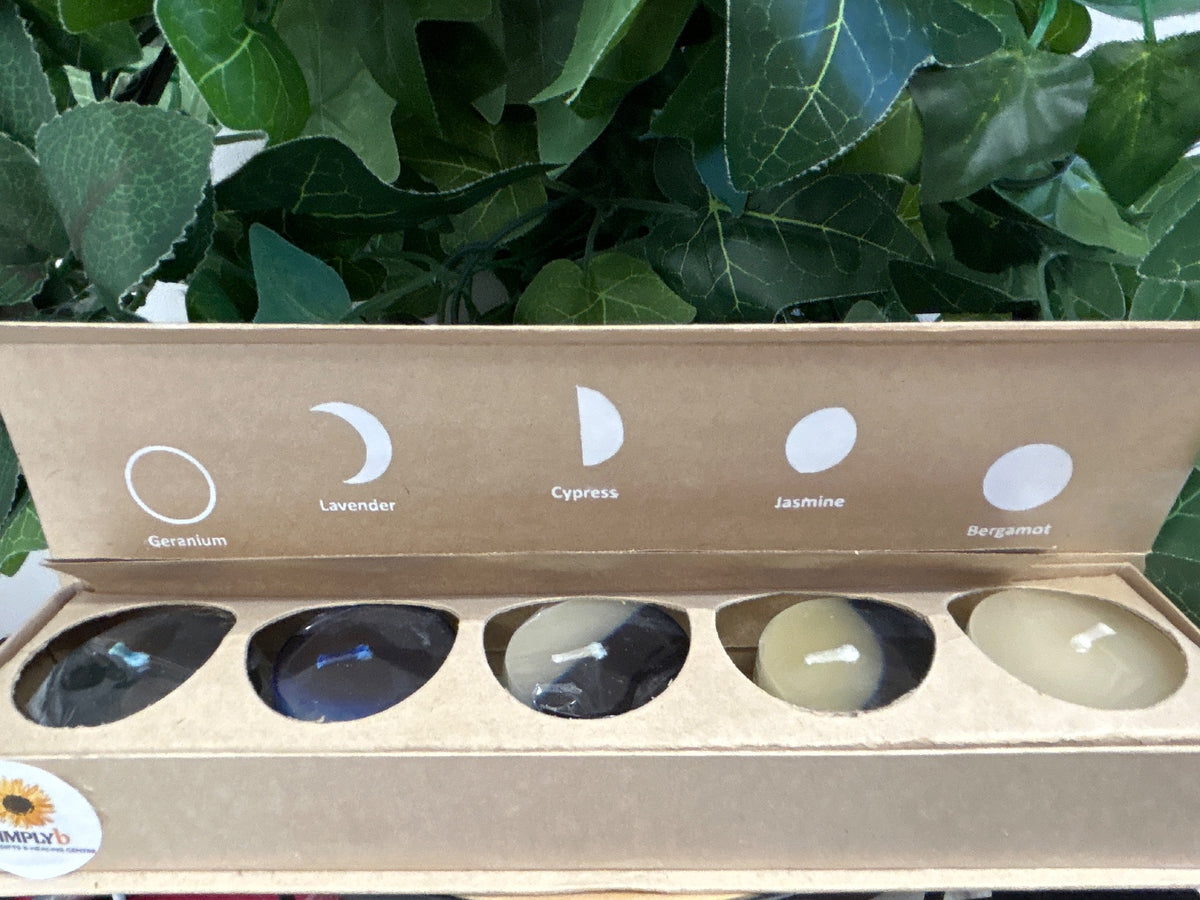 Five scented candles in kraft box with moon phase symbols and labels: Geranium, Lavender, Cypress, Jasmine, Bergamot.