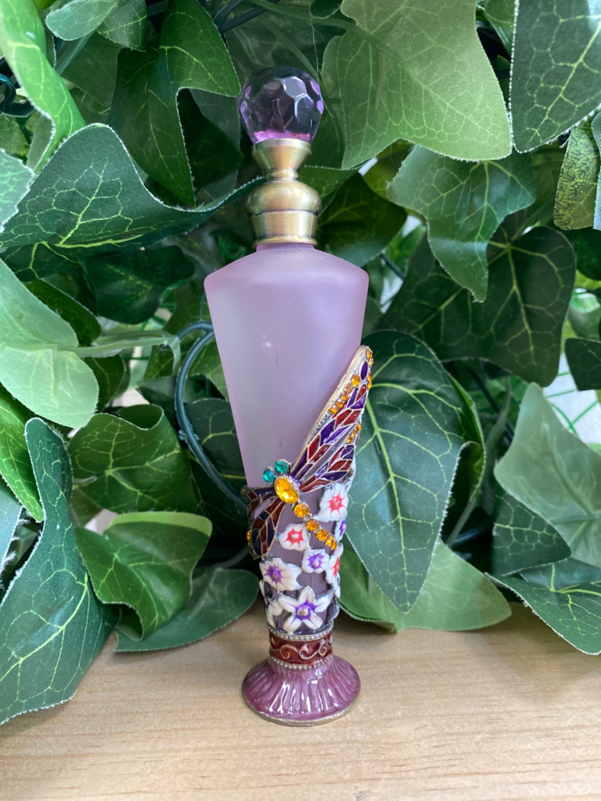 Pink frosted glass conical bottle with purple stopper, ornately painted dragonfly handle with coloured stones