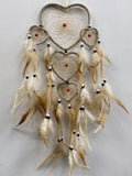 Heart-shaped dream catcher with cream feathers, beads, and nested hearts with red centres