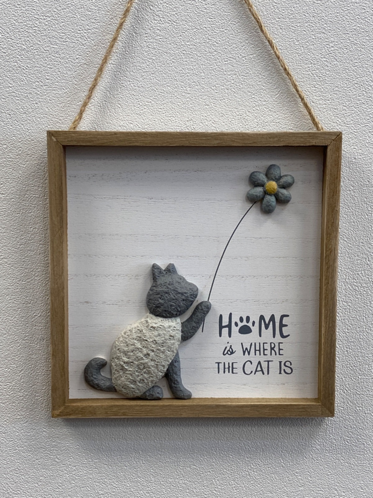 Wooden framed plaque with a grey stone cat holding a flower, text reading 'HOME is WHERE THE CAT IS'