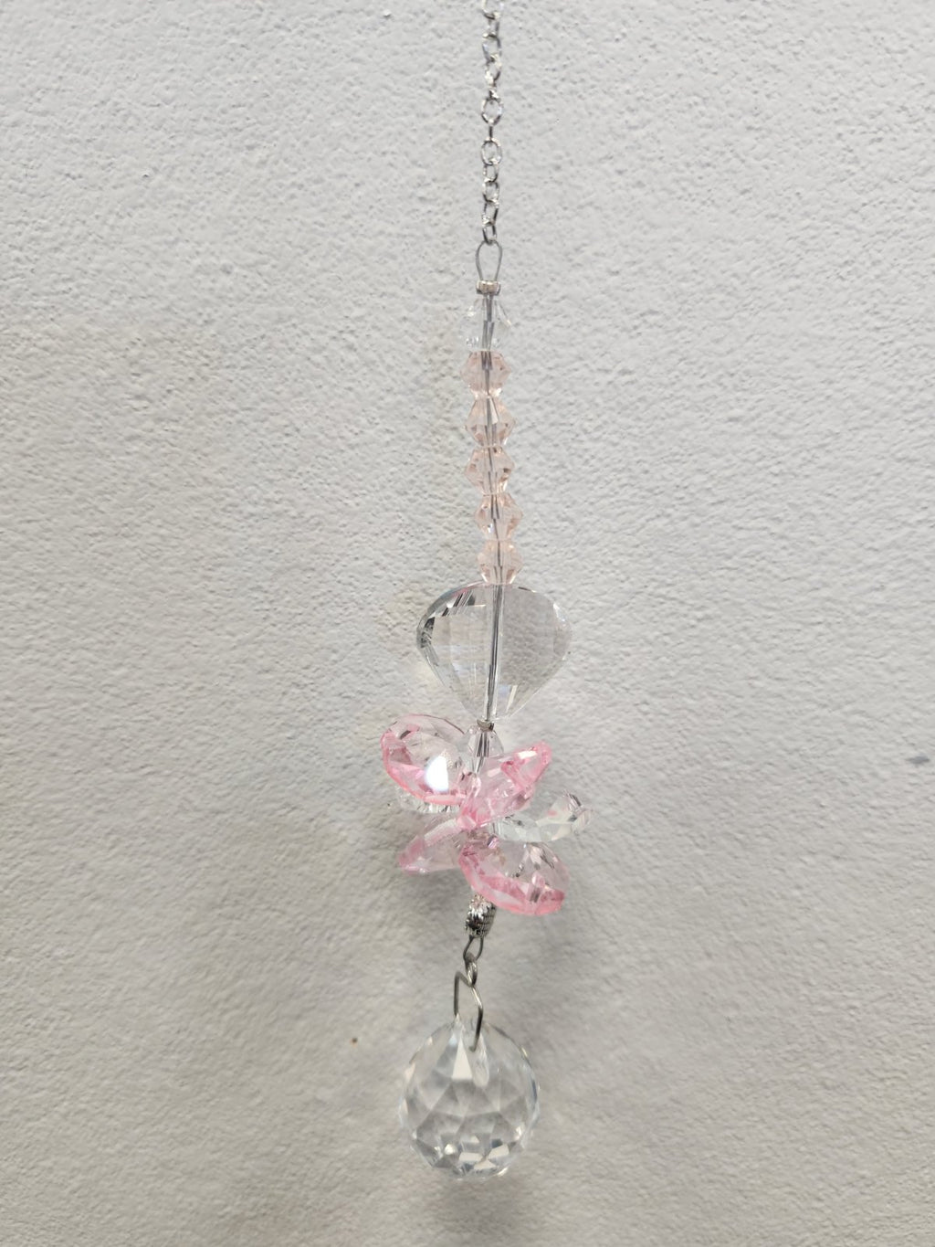 Pink beaded suncatcher with clear faceted charms hanging from a silver chain
