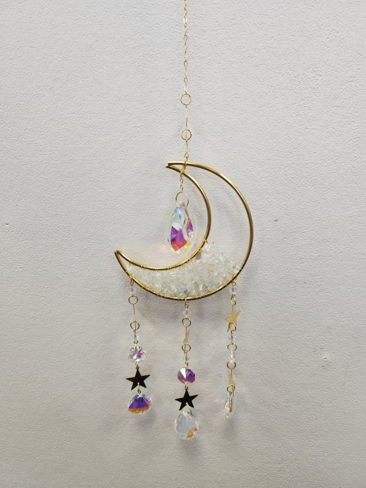 Gold half-moon suncatcher with clear quartz, rainbow crystals, and black stars hanging from chains