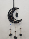 Black beaded crescent moon dreamcatcher with onyx teardrop and three hanging chains with black stone charms.