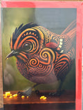 Fantail greeting card with Māori geometric patterns in orange, gold, and black on a gradient background