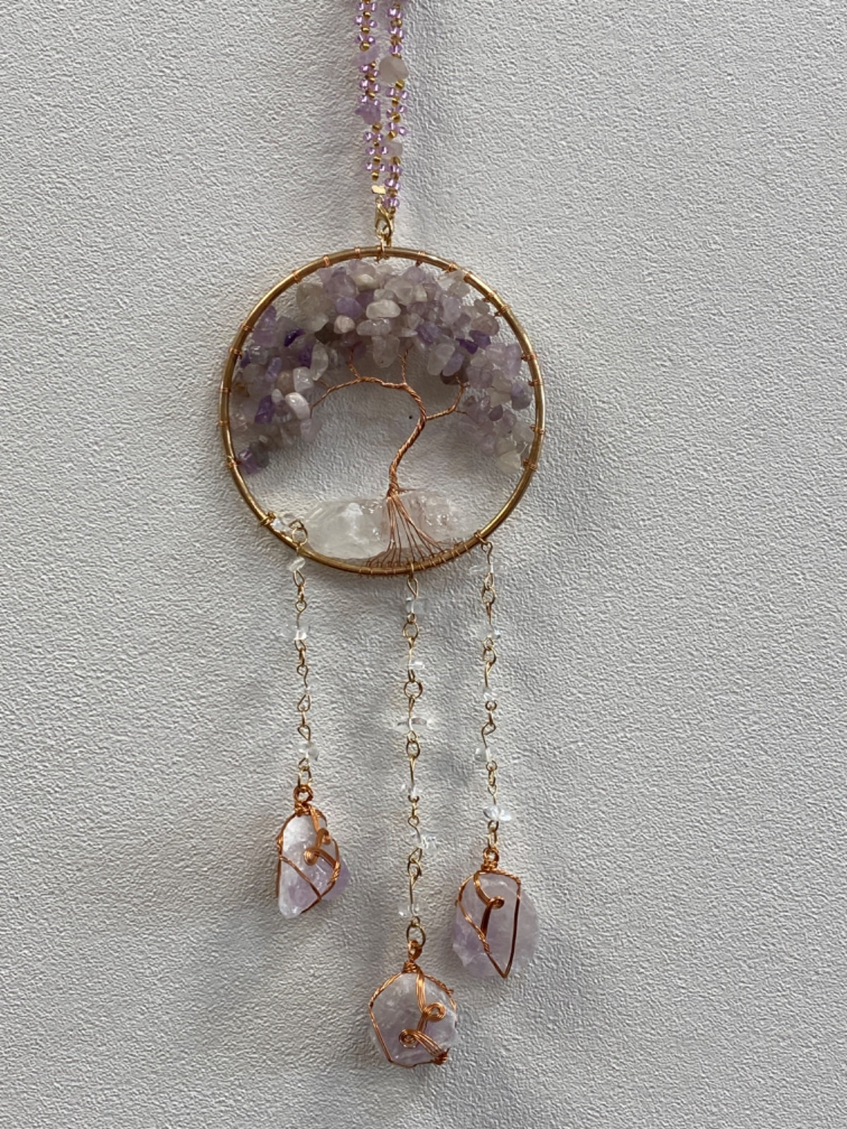 Small Tree of Life hanger with rose de France amethyst chips in a brass wire circle, three wrapped raw crystal drops hanging below.