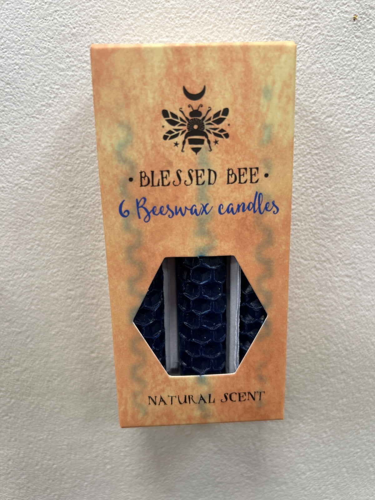 Pack of 6 natural blue beeswax candles in kraft packaging with hexagonal window showing the candles inside
