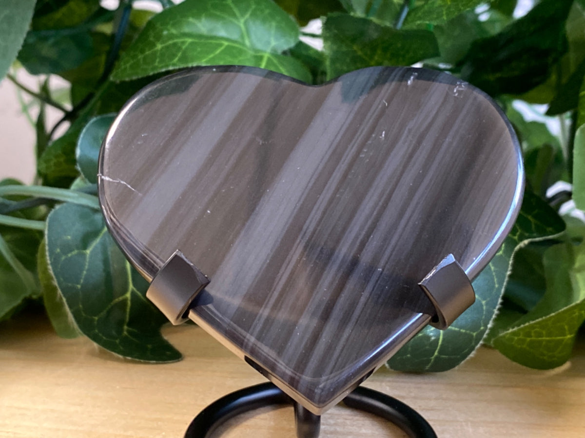 Heart-shaped Midnight Lace Obsidian polished stone, 7cm, with metallic grey striations and two metal stand feet
