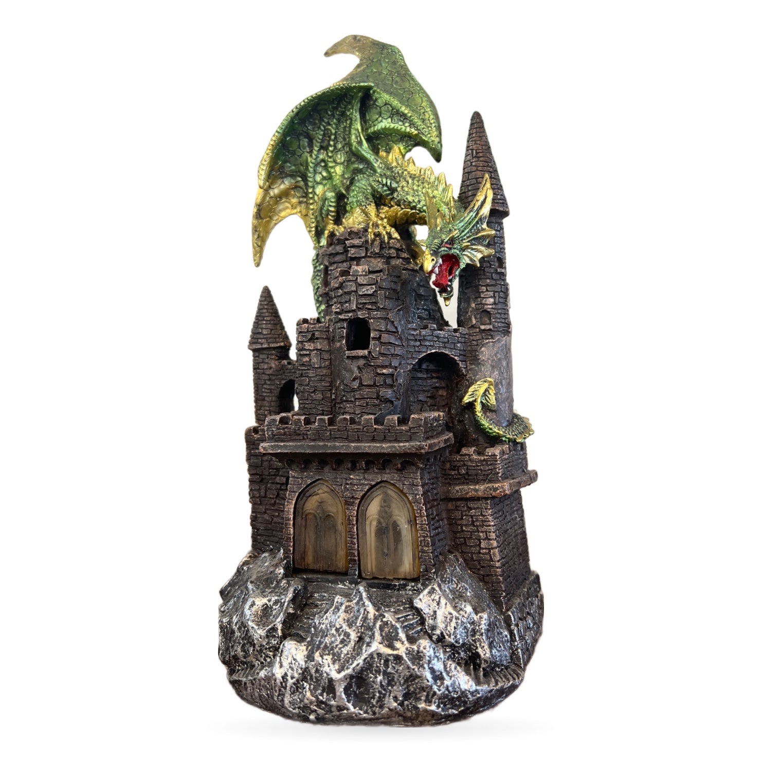 Green and gold dragon perched on dark stone castle tower with glowing red mouth, rocky base