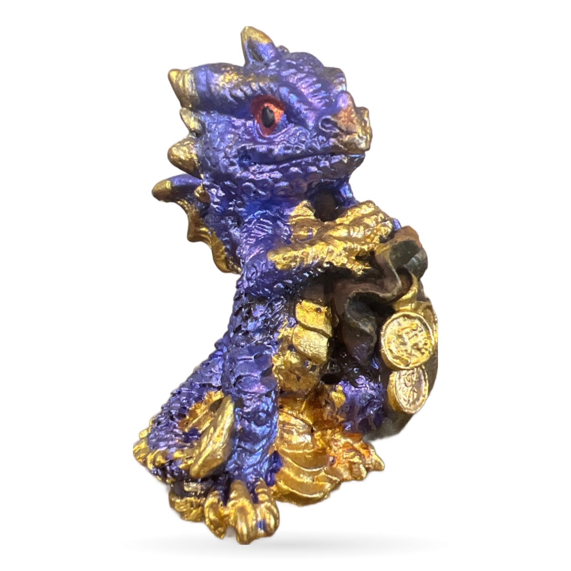 Purple and gold decorative dragon figurine with treasure bags and red eye detail