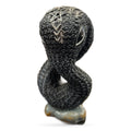 Black carved snake sculpture with pagan symbols and pale stone base
