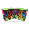 Colorful geometric transformable cube with lime green top, pink sides, and multicolored triangular facets in blue, orange, yellow, and purple