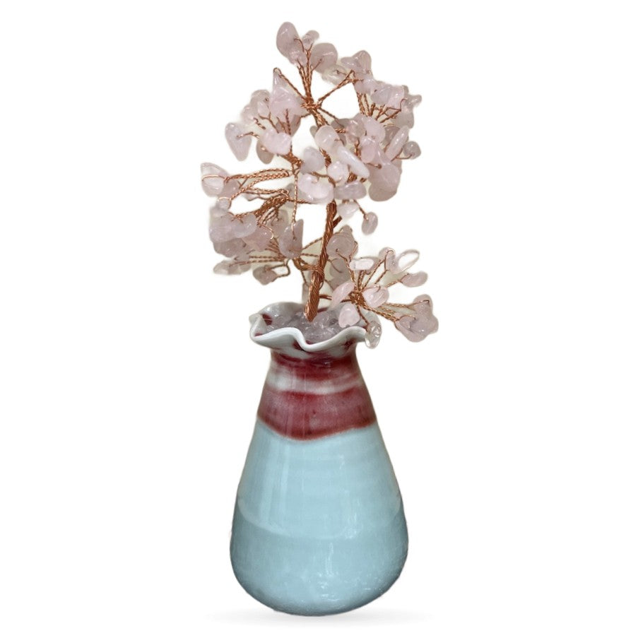Rose quartz crystal money tree with pale pink stone leaves on copper wire branches in a two-tone ceramic pot