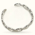 Silver adjustable twist ring with spiraled metal band design on white background