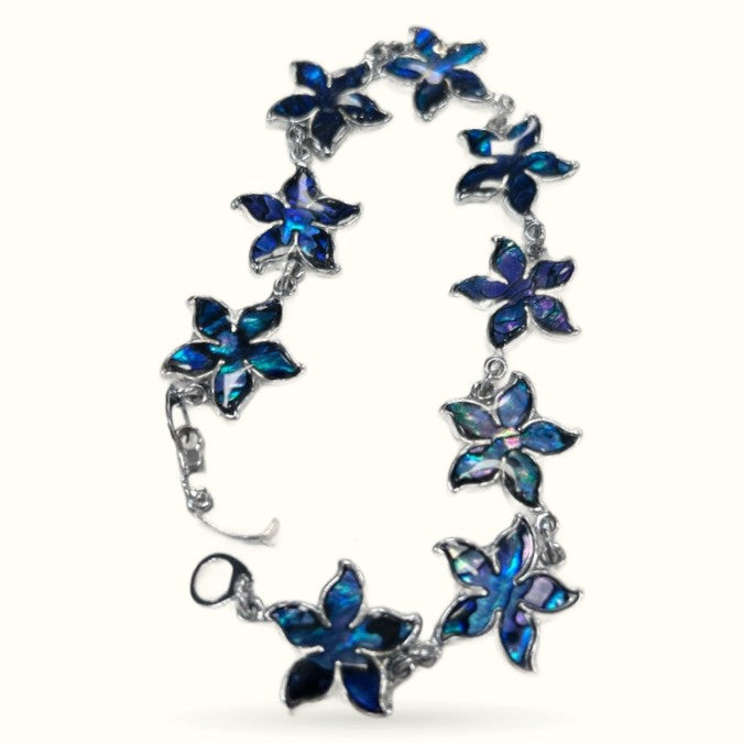 Paua flower shell bracelet with blue iridescent five-petal flower charms linked with silver-tone metal