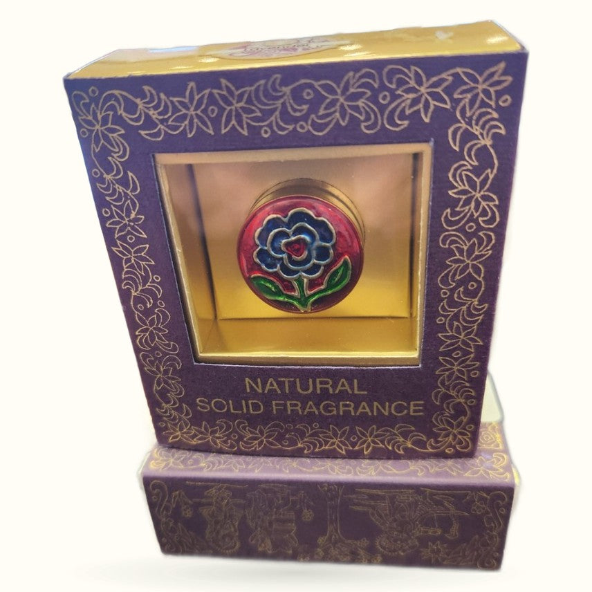 Purple ornate box containing natural solid fragrance with decorative flower emblem