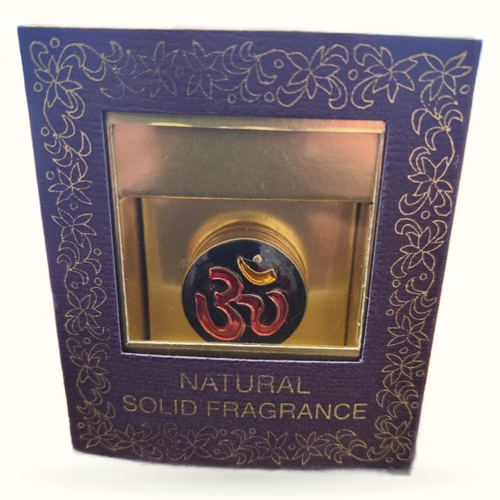 Purple decorative box with gold ornamental border containing gold jar with red Om symbol solid fragrance