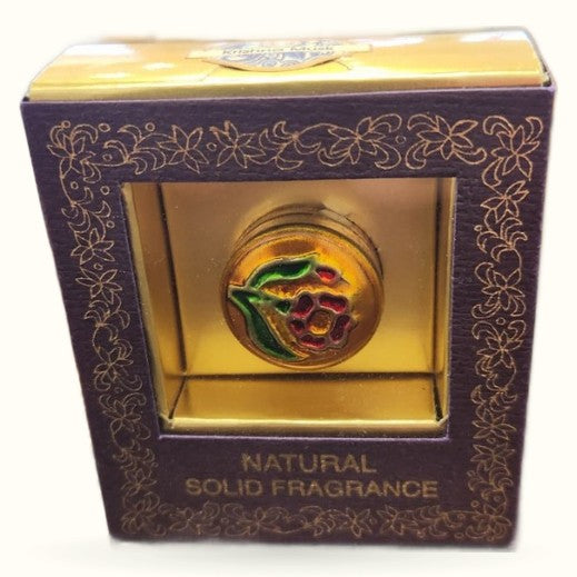 Krishna Musk solid fragrance in ornate navy and gold packaging with decorative sphere visible