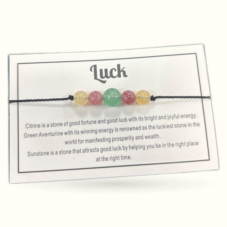 Luck bracelet with five polished gemstone beads on black cord with informational card