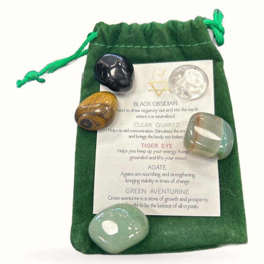 Green velvet pouch with five polished crystals and an information card describing their metaphysical properties
