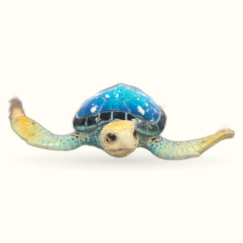 Blue marble sea turtle figurine with yellow-green flippers, viewed from above against white background
