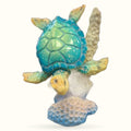 Blue and green decorative turtle figurine perched on white and blue textured coral base