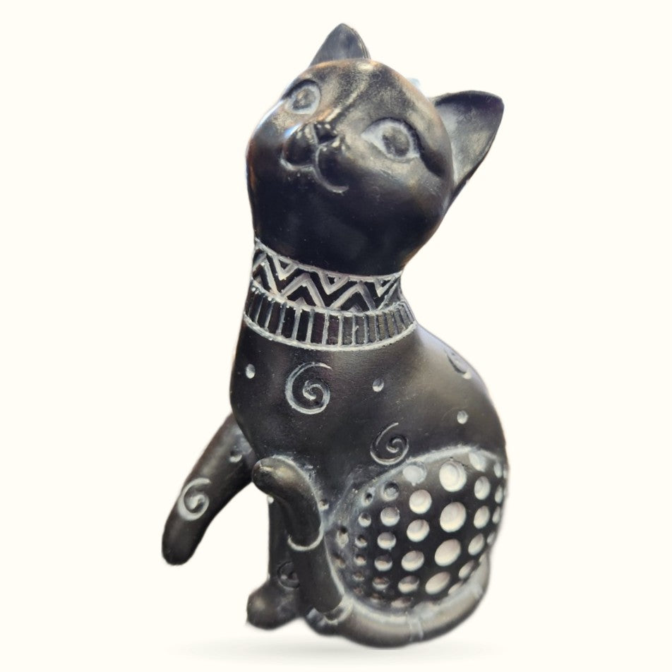 Black ceramic cat ornament sitting upright with decorative collar and patterned belly, 12cm tall