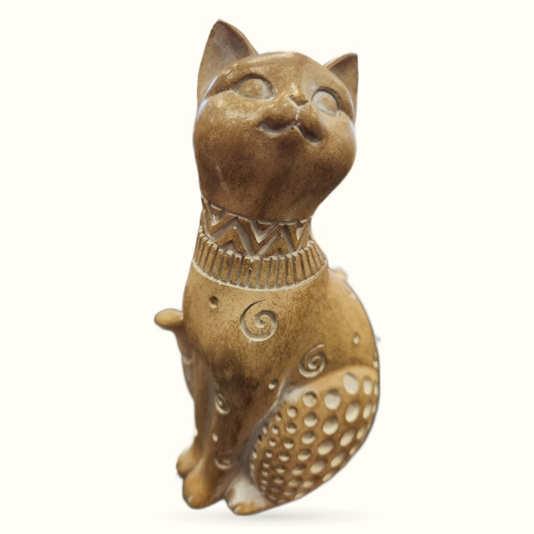 Bronze-toned decorative cat ornament sitting upright with head tilted upward, ornate collar and patterned body