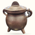 Small bronze pewter cauldron with lid, three feet, and decorative handles on white background
