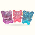 Three translucent bear-shaped toys in purple, pink, and blue with glitter sparkle finish