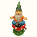 Colorful garden gnome figurine sitting on a red spotted mushroom with green grass base