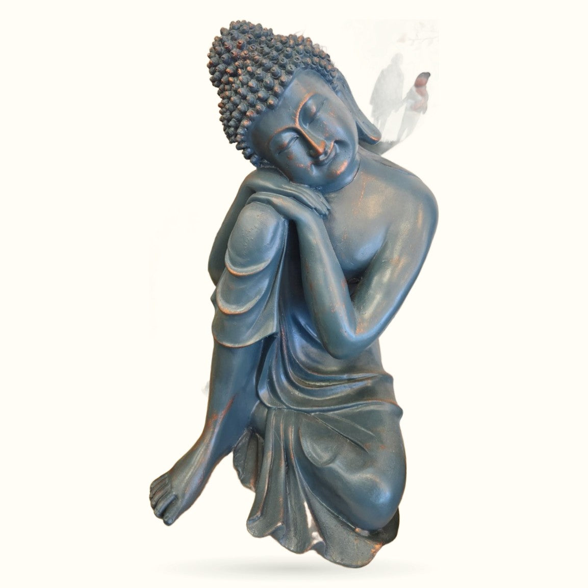 Blue Buddha statue with textured curled hair, peaceful expression, draped robes, and white feather accent