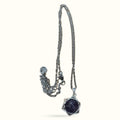 Silver chain necklace with dark blue star-shaped pendant featuring a polished spherical stone