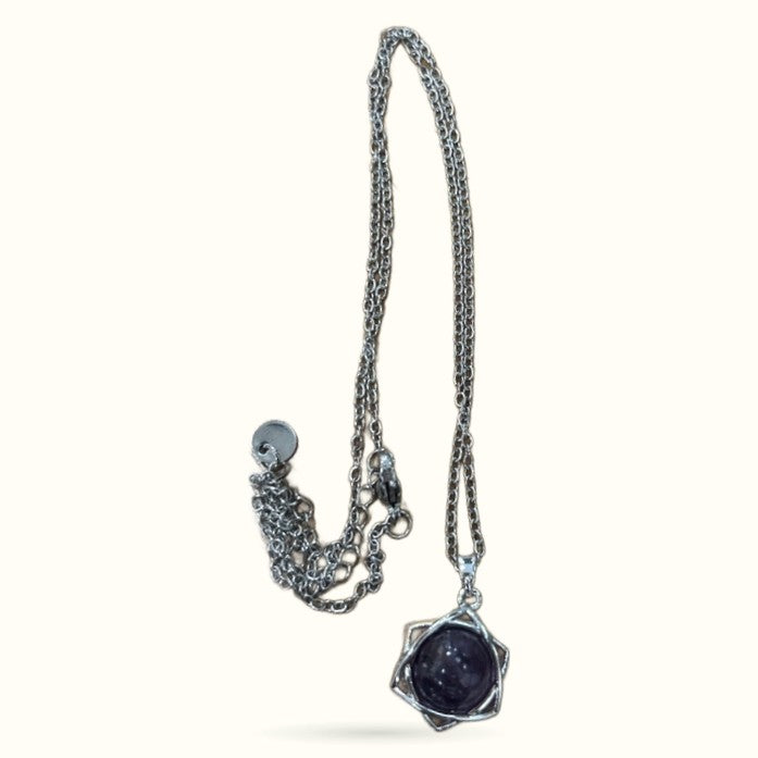 Silver chain necklace with dark blue star-shaped pendant featuring a polished spherical stone