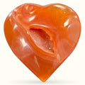 Polished carnelian geode heart with deep orange coloring and sparkly crystal-lined cavity