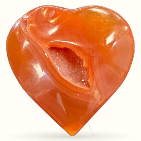 Polished carnelian geode heart with deep orange coloring and sparkly crystal-lined cavity