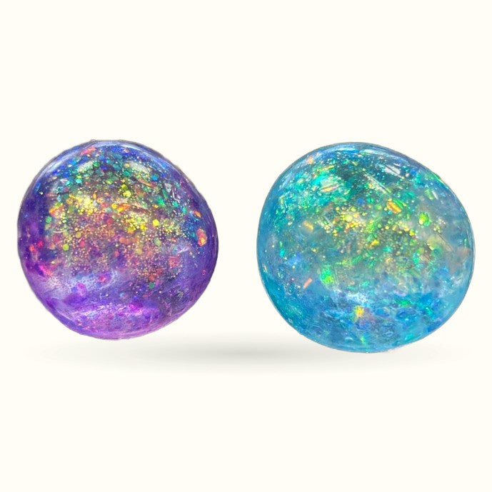 Two glitter squishy balls - one purple with gold sparkles, one turquoise with rainbow iridescent glitter
