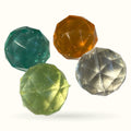 Four faceted sparkly bouncy balls in teal, lime green, amber, and clear colors with reflective surfaces