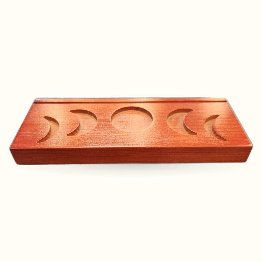 Wooden tarot card holder with five carved moon phase designs on warm reddish-brown surface