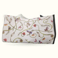 Cream tote bag with decorative vine scrolls, native birds, and red flowers in botanical pattern