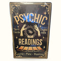 Vintage-style black tin sign with gold text reading 'Psychic Readings' featuring crystal ball and tarot imagery