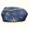 Navy blue makeup bag with celestial design featuring gold moons, stars, and sun motifs with gold zipper